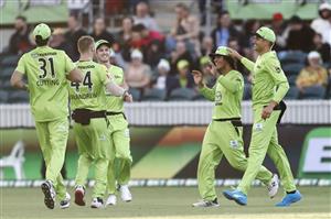 CANBERRA, AUSTRALIA - DECEMBER 22: Oliver Davies of the Thunder is congratulated by team mates after taking a catch to dismiss Josh Inglis of the Scorches during the Big Bash League match between the Sydney Thunder and the Perth Scorchers at Manuka Oval, on December 22, 2020, in Canberra, Australia. (Photo by Darrian Traynor/Getty Images)