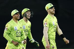 CANBERRA, AUSTRALIA - DECEMBER 22: Usman Khawaja of the Thunder celebrates with team mates after taking a catch to dismiss Jason Roy of the Scorches during the Big Bash League match between the Sydney Thunder and the Perth Scorchers at Manuka Oval, on December 22, 2020, in Canberra, Australia. (Photo by Darrian Traynor/Getty Images)