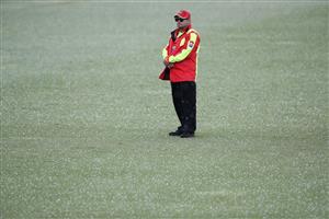 TAURANGA, NEW ZEALAND - DECEMBER 28: A security guard is pictured on the ground as hail falls during day three of the First Test match in the series between New Zealand and Pakistan at Bay Oval on December 28, 2020 in Tauranga, New Zealand. (Photo by Phil Walter/Getty Images)
