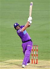 BRISBANE, AUSTRALIA - DECEMBER 30: Tim David of the Hurricanes hits the ball over the boundary for a six during the Big Bash League match between the Hobart Hurricanes and Brisbane Heat at The Gabba, on December 30, 2020, in Brisbane, Australia. (Photo by Bradley Kanaris/Getty Images)