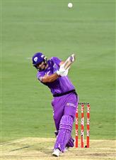 BRISBANE, AUSTRALIA - DECEMBER 30: Tim David of the Hurricanes hits the ball over the boundary for a six during the Big Bash League match between the Hobart Hurricanes and Brisbane Heat at The Gabba, on December 30, 2020, in Brisbane, Australia. (Photo by Bradley Kanaris/Getty Images)