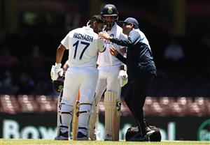 SYDNEY, AUSTRALIA - JANUARY 11: Rishabh Pant of India is assessed after being stuck on the helmet during day five of the 3rd Test match in the series between Australia and India at Sydney Cricket Ground on January 11, 2021 in Sydney, Australia. (Photo by Ryan Pierse/Getty Images)