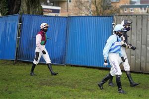 FONTWELL, ENGLAND - JANUARY 14: Jockey Bryony Frost (L) walks alone behind other jockeys on the way to the parade ring at Fontwell Park Racecourse on January 14, 2021 in Fontwell, England. Due to the Coronavirus pandemic, owners along with the paying public will not be allowed to attend the meeting. (Photo by Alan Crowhurst/Getty Images)