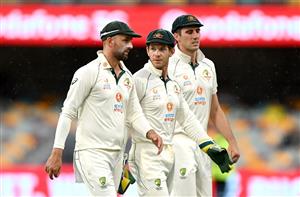 BRISBANE, AUSTRALIA - JANUARY 18: Tim Paine, Nathan Lyon and Pat Cummins of Australia are seen leaving the field as a rain delay is called during day four of the 4th Test Match in the series between Australia and India at The Gabba on January 18, 2021 in Brisbane, Australia. (Photo by Bradley Kanaris/Getty Images)