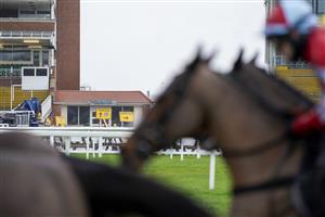 NEWBURY, ENGLAND - JANUARY 20: Runners pass the signs in the grandstand area as the course is a Covid-19 vaccination hub when racing is not taking place at Newbury Racecourse on January 20, 2021 in Newbury, England. Due to the Coronavirus pandemic, owners along with the paying public will not be allowed to attend the meeting. (Photo by Alan Crowhurst/Getty Images)