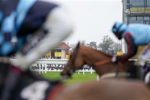 NEWBURY, ENGLAND - JANUARY 20: Runners pass the signs in the grandstand area as the course is a Covid-19 vaccination hub when racing is not taking place at Newbury Racecourse on January 20, 2021 in Newbury, England. Due to the Coronavirus pandemic, owners along with the paying public will not be allowed to attend the meeting. (Photo by Alan Crowhurst/Getty Images)