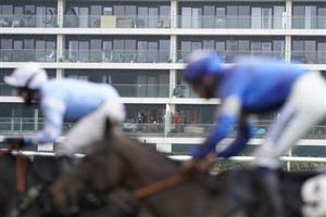 NEWBURY, ENGLAND - JANUARY 20: A general view as a resident of a flat that overlooks the course watches the action at Newbury Racecourse on January 20, 2021 in Newbury, England. Due to the Coronavirus pandemic, owners along with the paying public will not be allowed to attend the meeting. (Photo by Alan Crowhurst/Getty Images)