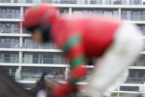 NEWBURY, ENGLAND - JANUARY 20: A general view as a resident of a flat that overlooks the course watches the action at Newbury Racecourse on January 20, 2021 in Newbury, England. Due to the Coronavirus pandemic, owners along with the paying public will not be allowed to attend the meeting. (Photo by Alan Crowhurst/Getty Images)