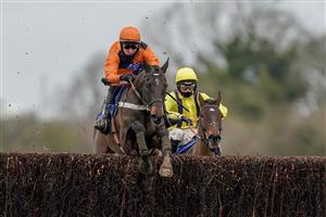 WINCANTON, ENGLAND - JANUARY 21: Niall Houlihan riding Mister Murchan (orange) clear the last to win The Follow racingtv On Instagram Novices' Handicap Chase at Wincanton Racecourse on January 21, 2021 in Wincanton, England. Due to the Coronavirus pandemic, owners along with the paying public will not be allowed to attend the meeting. (Photo by Alan Crowhurst/Getty Images)