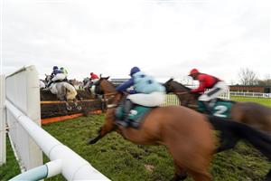 WARWICK, ENGLAND - FEBRUARY 03: A general view as runners clear the fence in front of the grandstands during The Watch On Racing TV Handicap Chase at Warwick Racecourse on February 03, 2021 in Warwick, England. Due to the Coronavirus pandemic, owners along with the paying public will not be allowed to attend the meeting. (Photo by Alan Crowhurst/Getty Images)