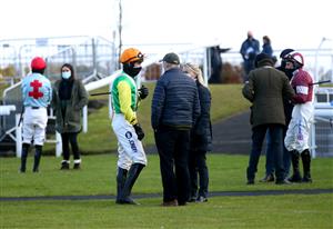 WETHERBY, ENGLAND - FEBRUARY 17: Jockey Ryan Mania (centre left) has a conversation in the parade ring prior to the beginning of the racingtv.com Handicap Hurdle at Wetherby Racecourse on February 17, 2021 in Wetherby, England. (Photo by Tim Goode - Pool/Getty Images)