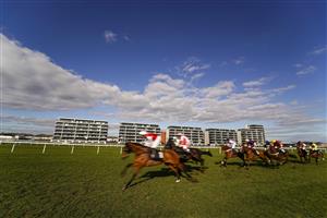 NEWBURY, ENGLAND - MARCH 06: A general view as runners pass the apartment blocks next to the track at Newbury Racecourse on March 06, 2021 in Newbury, England. Due to the coronavirus pandemic, owners along with the paying public will not be allowed to attend the meeting. (Photo by Alan Crowhurst/Getty Images)