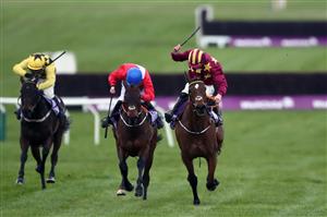 CHELTENHAM, ENGLAND - MARCH 19: Minella Indo ridden by Jack Kennedy (scarlet and yellow) on his way to winning the WellChild Cheltenham Gold Cup Chase on day four of the Cheltenham Festival at Cheltenham Racecourse on March 19, 2021 in Cheltenham, England. Sporting venues around the UK remain under strict restrictions due to the Coronavirus Pandemic as Government social distancing laws prohibit spectators inside venues resulting in events being held behind closed doors. (Photo by Tim Goode - Pool/Getty Images)