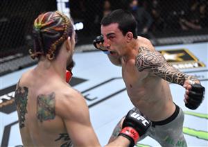 LAS VEGAS, NEVADA - MARCH 27: In this handout image provided by UFC, (R-L) Thomas Almeida of Brazil punches Sean O'Malley in their bantamweight fight during the UFC 260 event at UFC APEX on March 27, 2021 in Las Vegas, Nevada. (Photo by Jeff Bottari/Zuffa LLC via Getty Images)