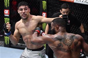 LAS VEGAS, NEVADA - MARCH 27: In this handout image provided by UFC, (L-R) Vicente Luque punches Tyron Woodley in their welterweight fight during the UFC 260 event at UFC APEX on March 27, 2021 in Las Vegas, Nevada. (Photo by Jeff Bottari/Zuffa LLC via Getty Images)