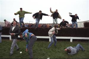 5 Apr 1997: The crowd sieze the opportunity to jump the famous fences at Aintree due to the evacuation of the stands, caused by the IRA bomb scare which postponed The Grand National to April 7th at the Aintree Racecourse, Liverpool, England. \ MandatoryCredit: David Rogers /Allsport
