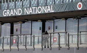 LIVERPOOL, ENGLAND - APRIL 10: A member of staff wipes down the railing in the empty stands at Aintree Racecourse ahead of Grand National Day of the 2021 Randox Health Grand National at Aintree Racecourse on April 10, 2021 in Liverpool, England. (Photo by Tim Goode - Pool/Getty Images)