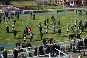 LIVERPOOL, ENGLAND - APRIL 10: Jockeys, owners and trainers stand for a two minute silence in the parade ring, following yesterdays announcement of the death of the Duke of Edinburgh at the age of 99, during Grand National Day of the 2021 Randox Health Grand National Festival at Aintree Racecourse on April 10, 2021 in Liverpool, England. (Photo by Tim Goode - Pool/Getty Images)