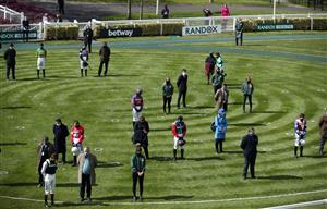 LIVERPOOL, ENGLAND - APRIL 10: Jockeys, owners and trainers stand for a two minute silence in the parade ring, following yesterdays announcement of the death of the Duke of Edinburgh at the age of 99, during Grand National Day of the 2021 Randox Health Grand National Festival at Aintree Racecourse on April 10, 2021 in Liverpool, England. (Photo by Tim Goode - Pool/Getty Images)