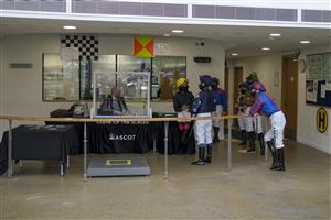 ASCOT, ENGLAND - APRIL 28: Jockeys gather around Robert Cuthbert before being called to the parade ring for The Longines Sagaro Stakes at Ascot Racecourse on April 28, 2021 in Ascot, England. Sporting venues around the UK remain under restrictions due to the Coronavirus Pandemic. Only owners are allowed to attend the meeting but the public must wait until further restrictions are lifted. (Photo by Alan Crowhurst/Getty Images)