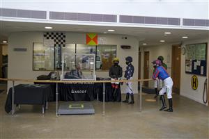 ASCOT, ENGLAND - APRIL 28: Jockeys gather around Robert Cuthbert before being called to the parade ring for The Longines Sagaro Stakes at Ascot Racecourse on April 28, 2021 in Ascot, England. Sporting venues around the UK remain under restrictions due to the Coronavirus Pandemic. Only owners are allowed to attend the meeting but the public must wait until further restrictions are lifted. (Photo by Alan Crowhurst/Getty Images)