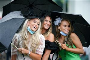 EPSOM, ENGLAND – JUNE 4: Racegoers use umbrellas to shelter from the rain during day one of the Cazoo Derby Festival at Epsom Racecourse on June 4, 2021 in Epsom, England. (Photo by John Walton-Pool/Getty Images)