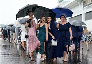 EPSOM, ENGLAND – JUNE 4: Racegoers use umbrellas to shelter from the rain during day one of the Cazoo Derby Festival at Epsom Racecourse on June 4, 2021 in Epsom, England. (Photo by John Walton-Pool/Getty Images)