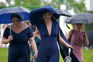 EPSOM, ENGLAND – JUNE 4: Racegoers try to shelter from the rain during day one of the Cazoo Derby Festival at Epsom Racecourse on June 4, 2021 in Epsom, England. (Photo by John Walton-Pool/Getty Images)