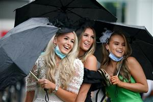 EPSOM, ENGLAND – JUNE 4: Racegoers use umbrellas to shelter from the rain during day one of the Cazoo Derby Festival at Epsom Racecourse on June 4, 2021 in Epsom, England. (Photo by John Walton-Pool/Getty Images)