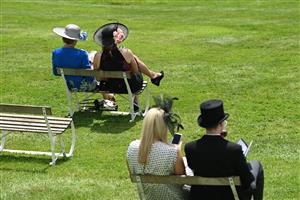 Racegoers sit on socially distanced seating as they wait for racing to start on the second day of the Epsom Derby Festival horse racing event at Epsom Downs Racecourse in Surrey, southern England on June 5, 2021. (Photo by Glyn KIRK / AFP) (Photo by GLYN KIRK/AFP via Getty Images)