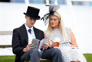 EPSOM, ENGLAND - JUNE 05: Racegoers look at a racecard during day two of the Cazoo Derby Festival at Epsom Racecourse on June 5, 2021 in Epsom, England. (Photo by John Walton - Pool/Getty Images)