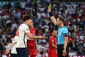 Dutch referee Danny Makkelie (R) presents a yellow card to England's defender Harry Maguire during the UEFA EURO 2020 semi-final football match between England and Denmark at Wembley Stadium in London on July 7, 2021. (Getty Images)