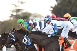 MELBOURNE, AUSTRALIA - JULY 10: Jamie Kah riding Red Santa out of the barriers before winning race 6, the Behind The Barriers Boxing Challenge 7/8, during Melbourne Racing at Caulfield Racecourse on July 10, 2021 in Melbourne, Australia. (Photo by Vince Caligiuri/Getty Images)