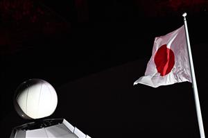 The Japanese national flag flies with the cauldron in background during the opening ceremony of the Tokyo 2020 Olympic Games, at the Olympic Stadium, in Tokyo, on July 23, 2021. (Getty Images)