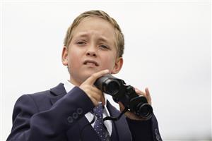 CHICHESTER, ENGLAND - JULY 31: A young racegoer with binoculars during the Qatar Goodwood Festival at Goodwood Racecourse on July 31, 2021 in Chichester, England. (Photo by Alan Crowhurst/Getty Images)