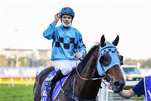 SYDNEY, AUSTRALIA - AUGUST 21: Tommy Berry (blue and black checks) on Mo'unga winning the Group 1 Winx Stakes at Royal Randwick on August 21, 2021 in Sydney, Australia. (Getty)