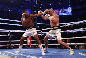 LONDON, ENGLAND - SEPTEMBER 25: Anthony Joshua punches as Oleksandr Usyk looks on during the Heavyweight Title Fight between Anthony Joshua and Oleksandr Usyk at Tottenham Hotspur Stadium on September 25, 2021 in London, England. (Getty Images)