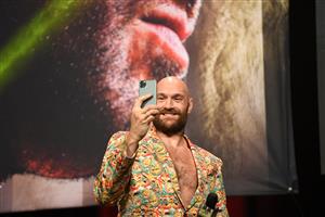 British boxer Tyson Fury uses his mobile phone as he attends a press conference with challenger US boxer Deontay Wilder (out of frame) for their WBC heavyweight championship fight, October 6, 2021 at the MGM Grand Garden Arena in Las Vegas, Nevada ahead of their October 9, 2021 fight. (Getty Images)